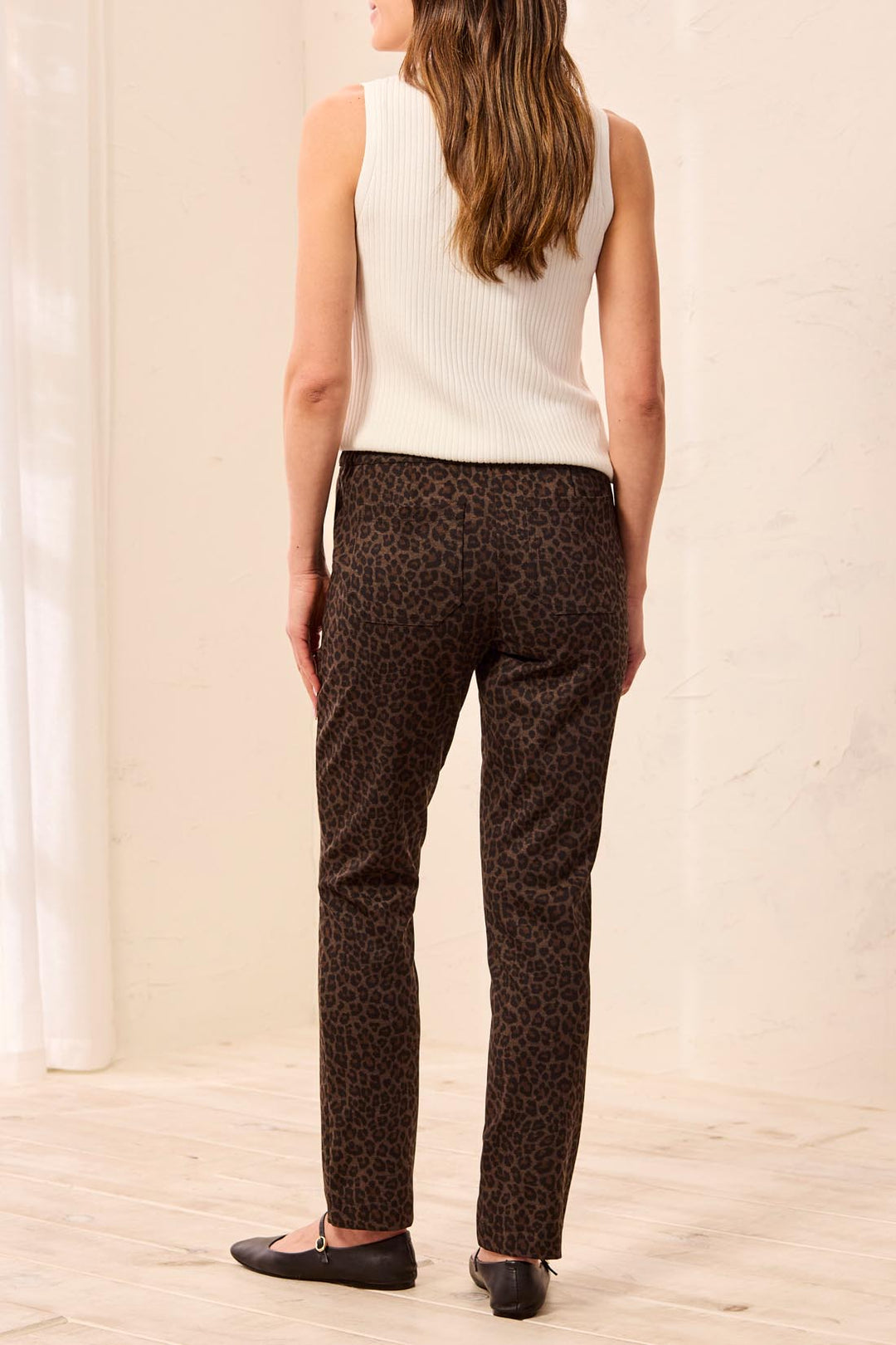 Tribal Pull On Ankle Pant with Pockets in Hickory, back view on model, showing back patch pockets, elastic waistband, and slim tapered leg in leopard print.