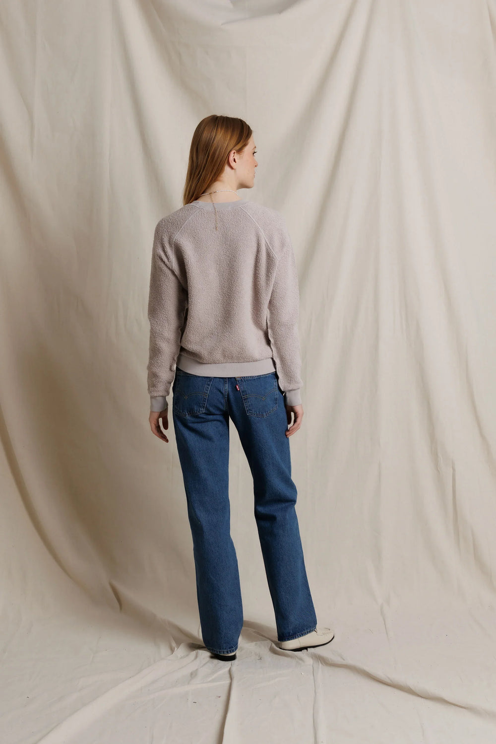 perfectwhitetee Ziggy Inside Out Fleece Sweatshirt in Cloud Gray, full-length back view on model, showing raglan seams, ribbed hem at the high hip, and ribbed cuffs, styled with straight-leg jeans and cream loafers